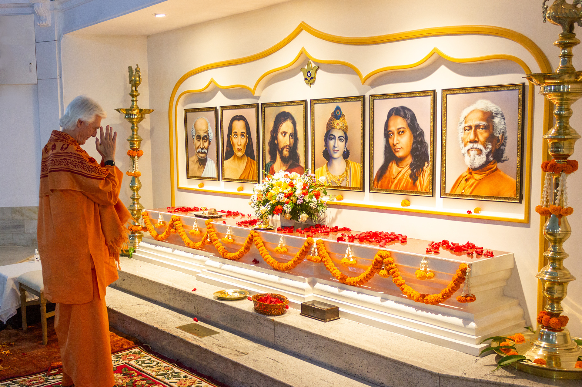 Brother Chidananda offers a floral tribute and pranams at the altar in the main meditation hall.